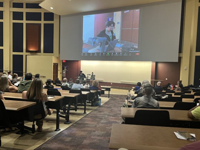 Speaker shown on screen in lecture hall